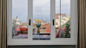 Janela com vista para área residencial, incluindo edifícios e céu claro.