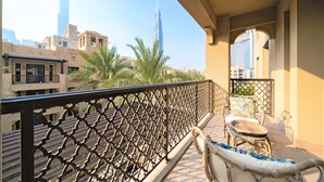 A balcony with a view of the Burj Khalifa, a wicker chair, and a small table. - Luxury 2bedroom in Dubai Downtown - Burj Views (Dubai)