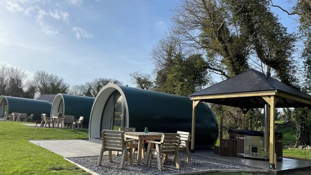 A series of dome-shaped cabins with outdoor seating areas, a gazebo, and a well-maintained lawn. - Kinelarty Luxury Glamping Pods (Downpatrick)