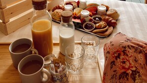 A breakfast setup with a variety of pastries, a bottle of juice, and a table with cups and glasses. - FURTHER.SPACE at Leitrim Lodge (Newry)