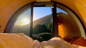 A room with a bed, a window, and a view of a mountain. - FURTHER.SPACE at Leitrim Lodge (Newry)