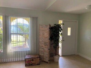 Enjoy a serene space with a large window, decorative screen, and potted plant.