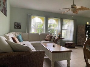 Relax in this inviting living room with a large sofa, coffee table, and wicker chair.