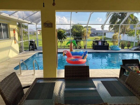 Relax by the pool with a clear view of the surrounding landscape, surrounded by lounge chairs and a table.