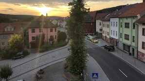 A cobblestone street lined with colorful buildings, a pedestrian crossing, and parked vehicles. - Rhöner Ferienwohnung (Dermbach)