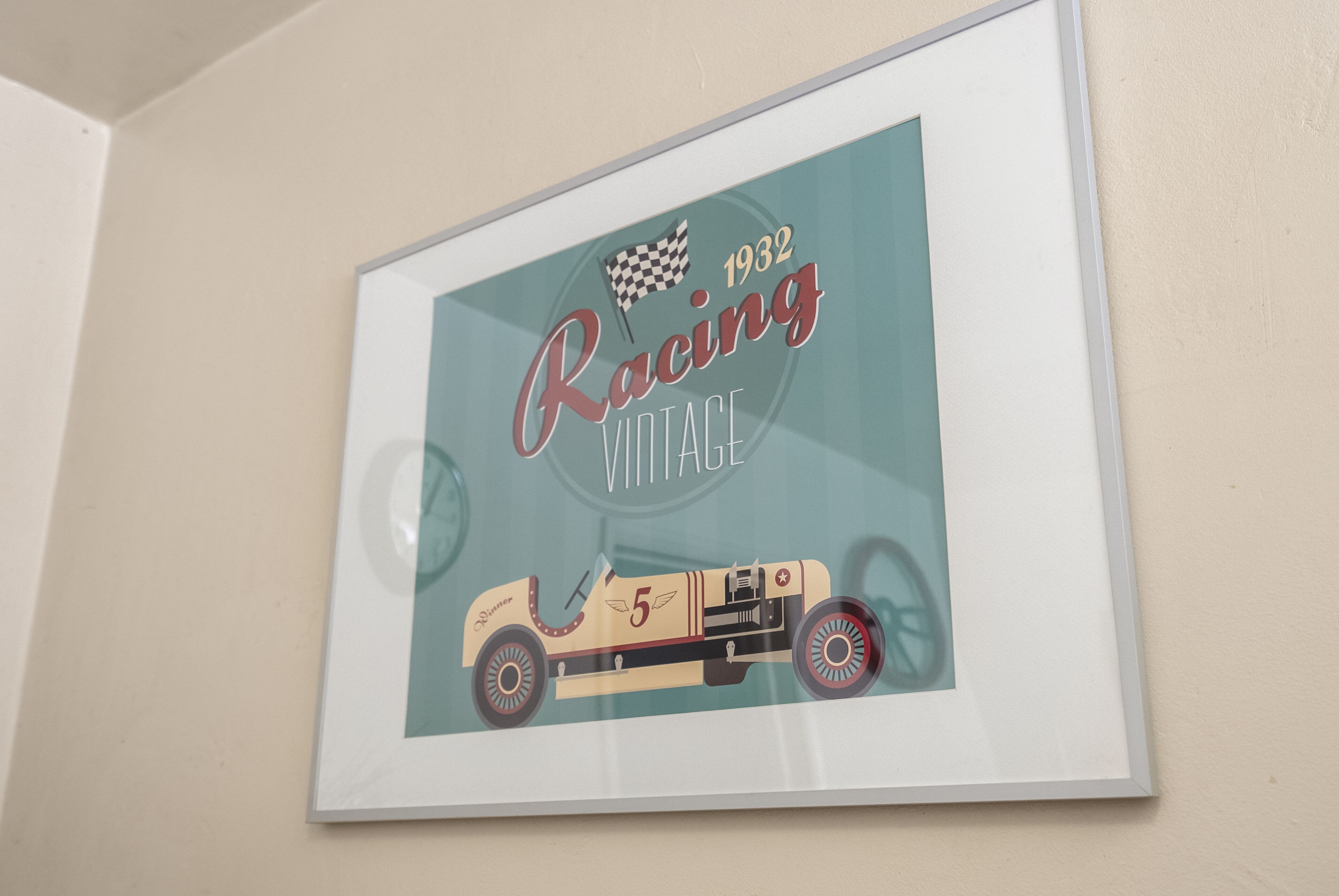 Ilustración antigua en marco de un coche de carreras con el texto 'Racing Vintage 1932' y una bandera a cuadros.