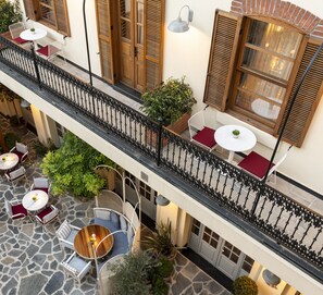 A multi-level outdoor terrace with stone flooring, multiple seating areas with tables and chairs, and potted plants. - Ecole St Pierre Hotel (Istanbul)