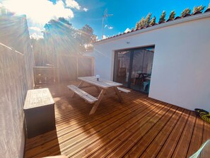 A wooden deck with a picnic table and a sliding glass door leading to a covered area. - ★ Family Suite “Noirmoutier” 300M Beach ★ (L'Épine)