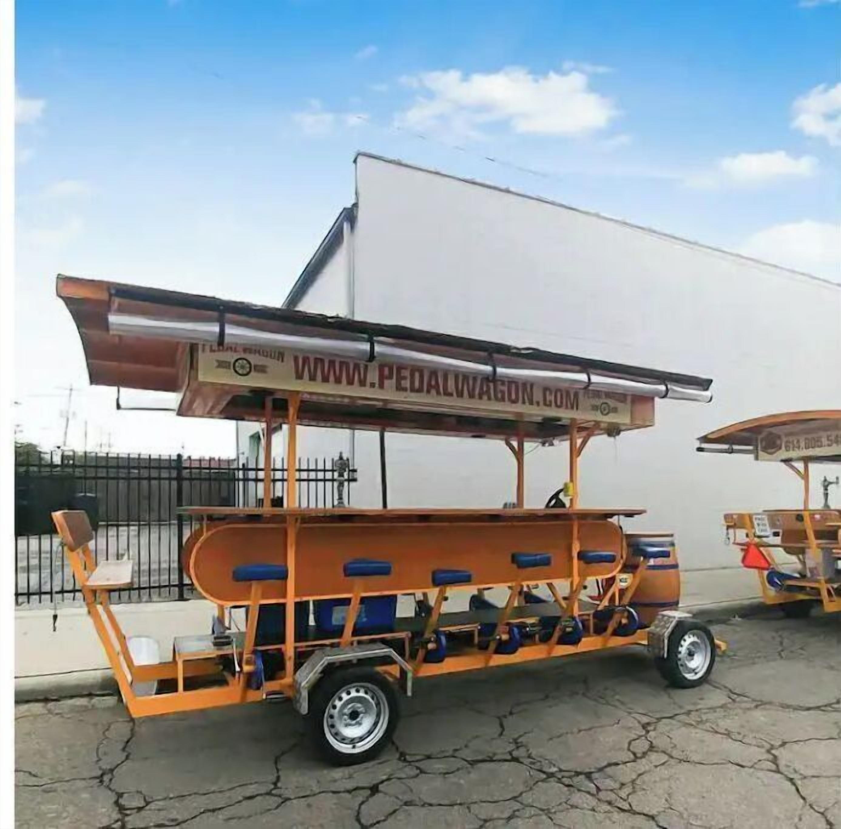A pedal-powered cart with a website URL displayed on its side.