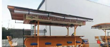 A pedal-powered cart with a website URL displayed on its side.
