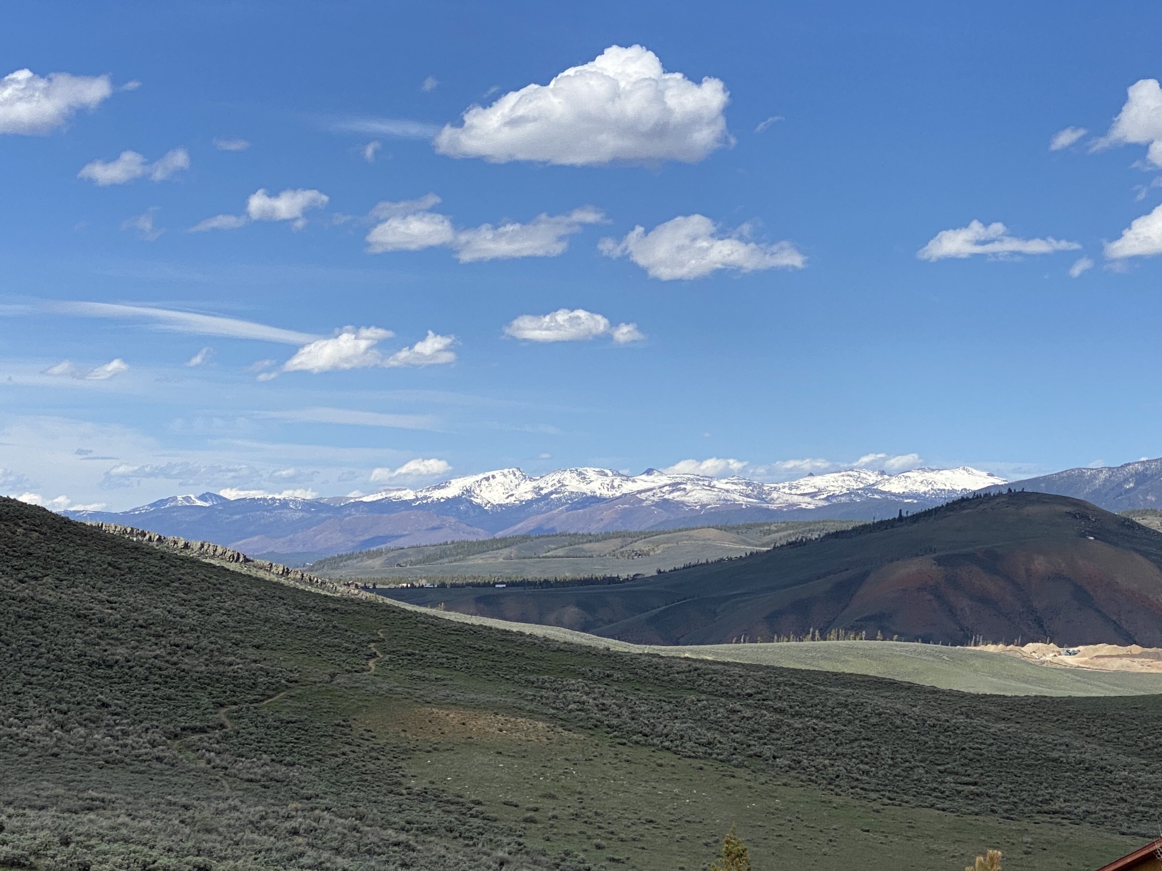A mountainous landscape with a clear sky and snow-capped peaks in the distance.