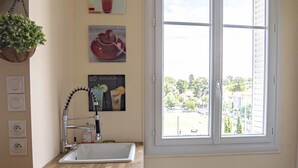 A kitchen with a window, a sink, and a faucet.