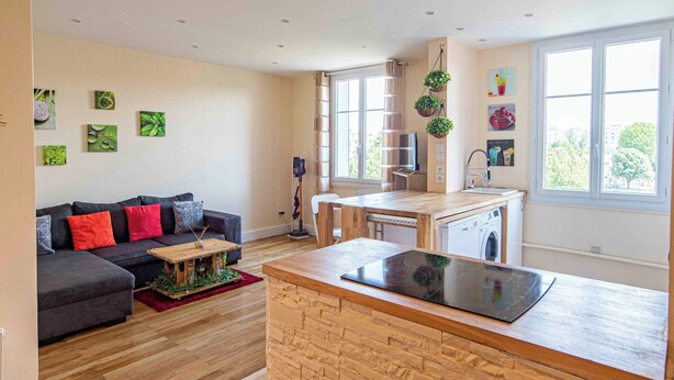 A modern apartment with a living area, a kitchen, and a dining space.