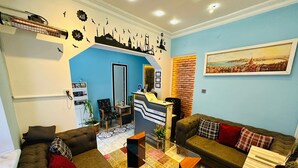 Una sala de estar acogedora con una pared azul de acento, un mostrador de recepción y un ventanal con vista a la ciudad.