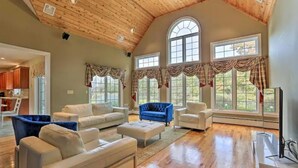 A spacious living room with a high wooden ceiling, large windows with curtains, and a modern fireplace. - Magnificent Villa, Private Pool, Fire Pit w/Huge Backyard (Chester)