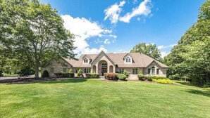 A two-story house with a stone facade, a front porch, and a well-maintained lawn. - Magnificent Villa, Private Pool, Fire Pit w/Huge Backyard (Chester)
