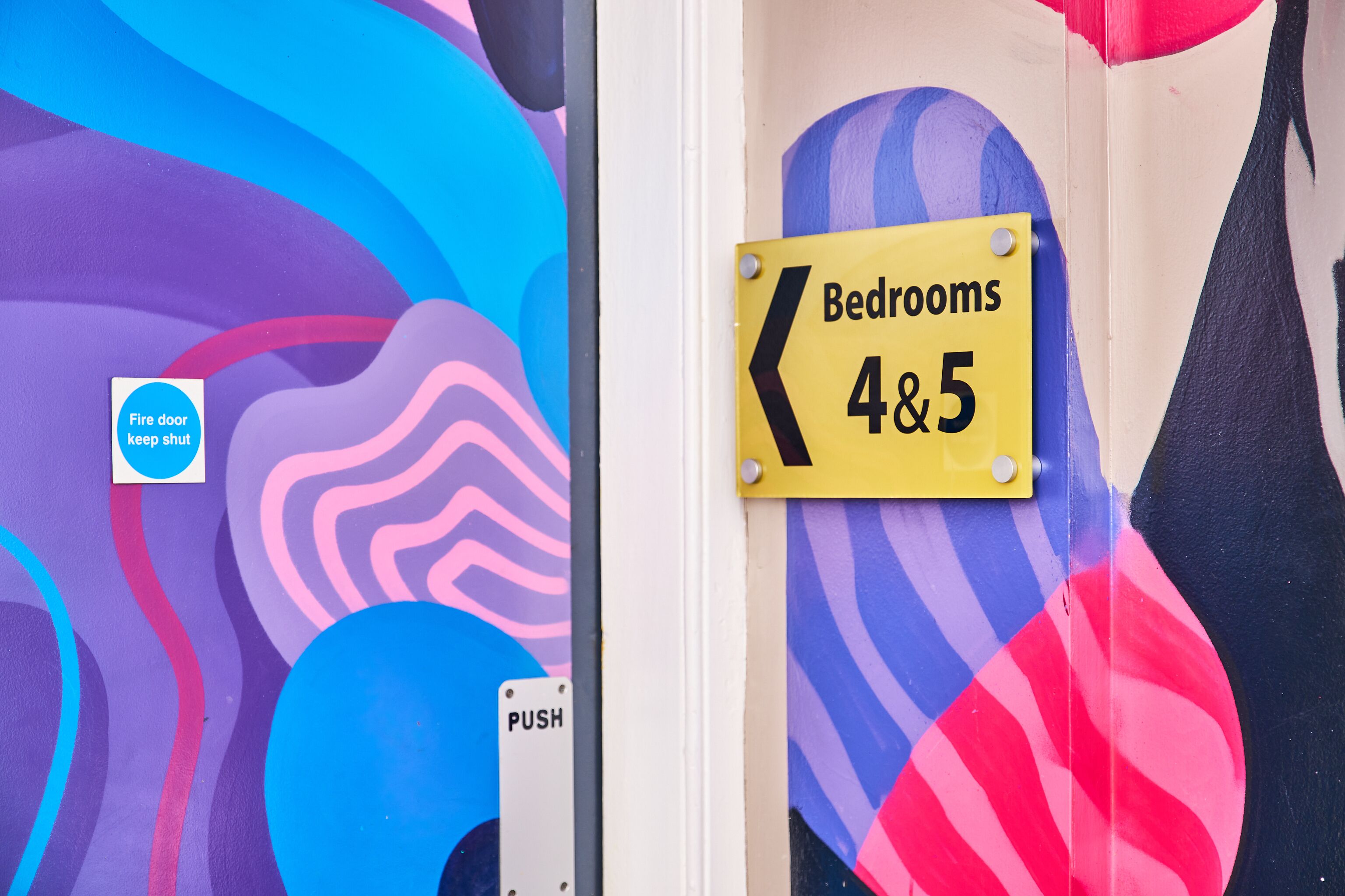 A colorful wall with a sign indicating 'Bedrooms 4&5'.