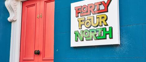 En byggnad med en röd dörr och en skylt med texten ”Forty Four North”.