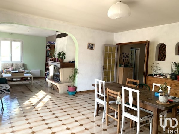 Un coin repas avec une table et des chaises en bois, une bibliothèque et une plante en pot.