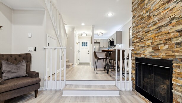 A modern living room with a staircase leading to a kitchen area. - Quiet Mountain Home with Fireplace, A+ Location (Banner Elk)