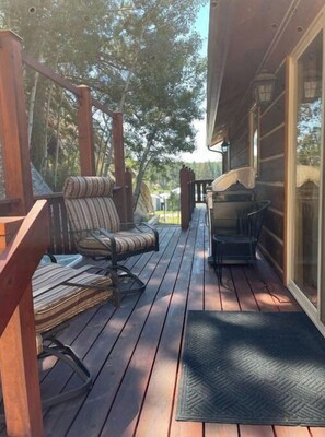 Relax on the deck with a cushioned chair or bench amidst lush surroundings.