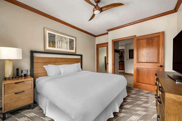 Relax in comfort with a large bed, nightstand, and wardrobe, plus a ceiling fan for a comfortable stay.