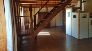 A wooden staircase leading to a second floor, a white refrigerator, and a clock on the wall. - Isolated house set in vineyards and woods (VALADY)