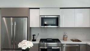 A modern kitchen with stainless steel appliances, a microwave, and a gas stove.