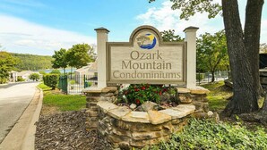 Letrero de Ozark Mountain Condominiums con base de piedra y un logotipo.