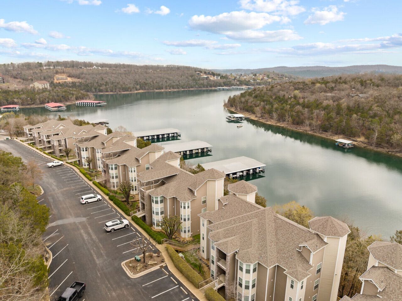 A residential area with apartment buildings, a parking lot, and a river with boats.
