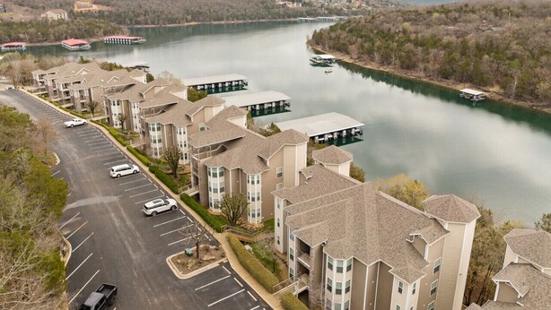 Zona residencial con edificios de apartamentos, un estacionamiento y un río con barcos.