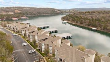 A residential area with apartment buildings, a parking lot, and a river with boats.