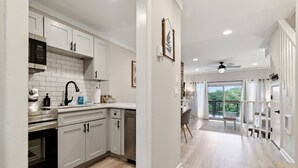 A modern kitchen with white cabinets, stainless steel appliances, and a wooden floor. - Peaceful MTN Haven with Fireplace & Views (Banner Elk)