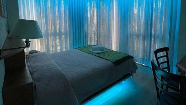 Una habitación de hotel con cama, escritorio y silla.