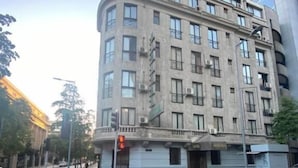 Un edificio de varios pisos con fachada curva, ventanas amplias y unidades de aire acondicionado.