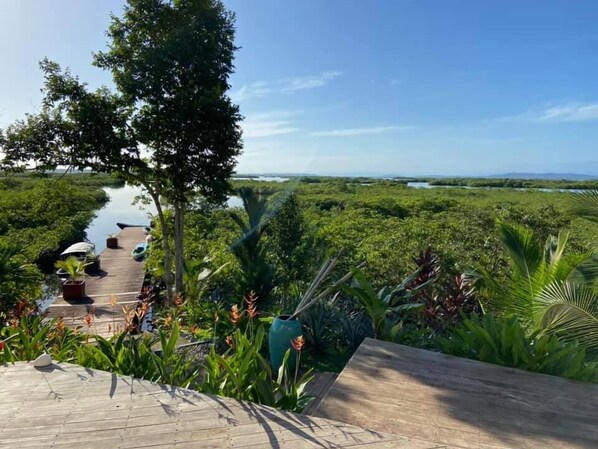 A wooden deck with a view of a lush landscape and water body.