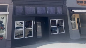 A two-story building with a dark facade, large windows, and a visible storefront. - The Studio Above the Studio (Jackson)