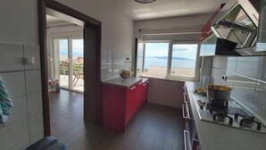 A modern kitchen with a large island, a gas stove, and a view of the sea through large windows. - A dreamlike view & private parking in Kastav, Apartment Alina (Kastav)