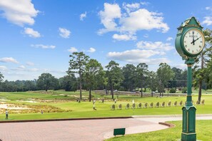Un parcours de golf avec une horloge Rolex et un panneau indiquant « Pinehurst ».