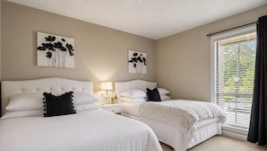 A hotel room with two beds, a nightstand, a lamp, and artwork on the walls. - Legends & Masters | Walk to Pinehurst Clubhouse | Hallmark-Style Charm (Pinehurst)