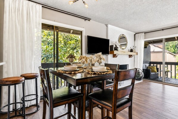 A dining area with a wooden table, chairs, and a TV mounted on the wall. - Legends & Masters | Walk to Pinehurst Clubhouse | Hallmark-Style Charm (Pinehurst)