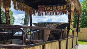 A tiki bar with a thatched roof and bamboo railings.