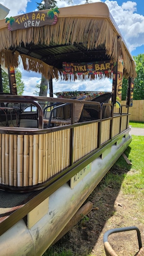 Un bar tiki con techo de paja y barandillas de bambú.