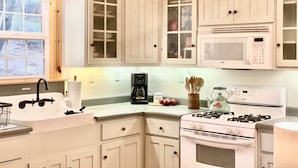 A kitchen with white cabinets, a gas stove, a microwave, and a coffee maker. - Duck Pond Cabin-Private Cabin on 400 Acre Ranch (Smartsville)