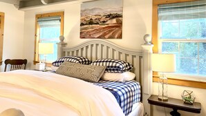 A bedroom with a large bed, a painting on the wall, and a window with blinds. - Duck Pond Cabin-Private Cabin on 400 Acre Ranch (Smartsville)