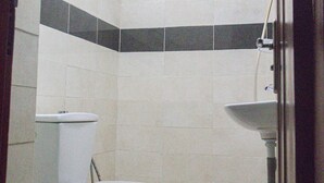 Un baño con inodoro, lavabo y ducha.