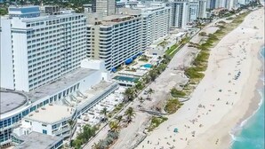 A coastal cityscape with high-rise buildings and a sandy beach.