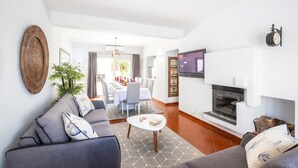 Uma sala de estar moderna com um conjunto de sofá, uma mesa de centro e uma lareira.
