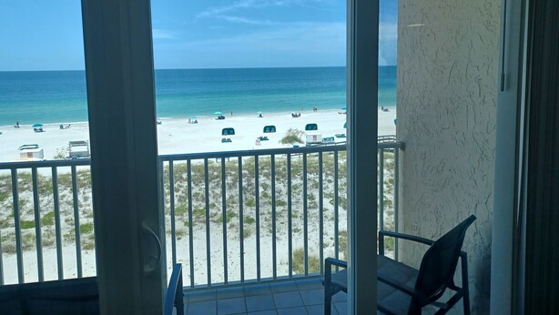 A balcony with a view of a beach and ocean.
