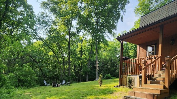 A wooden cabin with a porch and steps, surrounded by a grassy yard and trees. - Rustic Private Cabin on 30 acres w/Loft/Firepit/Secluded/Trails (Patriot)